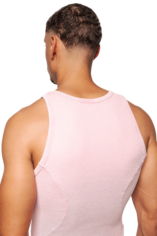 Rear view of a man in the E.O.I Cotton Candy tank top with OLAKALA logo on the left, close-fitting, emphasizing his shoulders and arms, against a white background.