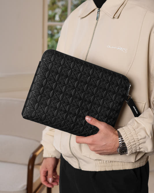 Person holding a black FREE GIFT Pochette Bag, offered as a free gift during the Black Friday sale at OLAKALA. Visual detail: black bag with white text.