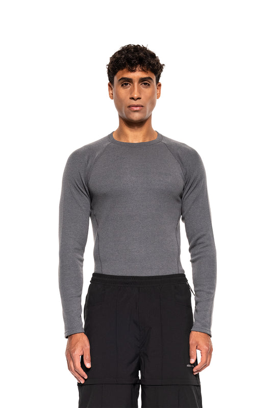 Ein schlanker Mann trägt das Terra Base Layer Longsleeve Grau, ein leichtes, atmungsaktives Funktionsshirt, ideal als erste Schicht für vielseitige Bewegungsfreiheit.