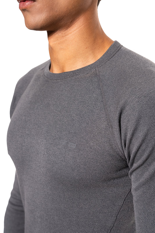 Nahaufnahme eines Mannes in einem Terra Base Layer Longsleeve Gray mit feinem Strickmuster und dezentem Logo auf der Brust, ideal für Schichtsysteme.