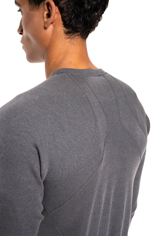 Männermodell trägt Terra Base Layer Longsleeve Grau; betont nahtlose Details und sportlichen Schnitt, ideal als Basisschicht für kühle Temperaturen.