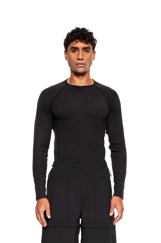 Junger Mann trägt das Terra Base Layer Longsleeve Black, ideal für Schichtsysteme im Winter, atmungsaktiv und angenehm, perfekt für vielseitige Bewegungsfreiheit.