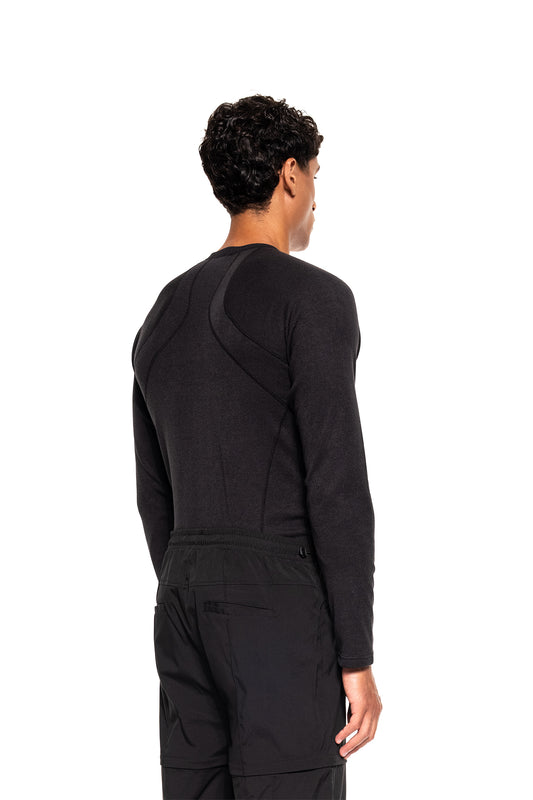 Person von hinten in Terra Base Layer Longsleeve Black, sichtbar sind Schulter- und Rückenpartien mit Nahtdetails, kombiniert mit elastischer Hose, ideal für funktionale Schichtensysteme.