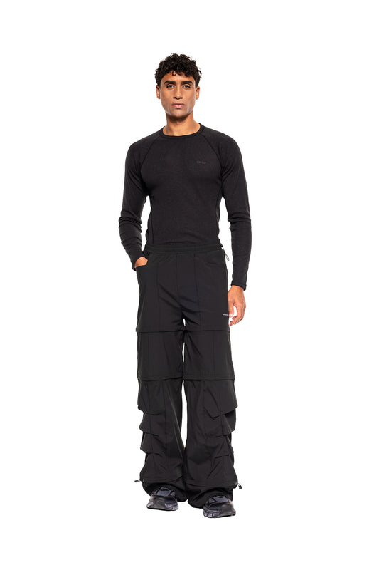 Männliches Modell trägt das Terra Base Layer Longsleeve Black, kombiniert mit locker sitzenden Cargo-Hosen und Sneakern, ideal für vielseitige Schichtung im Winter.