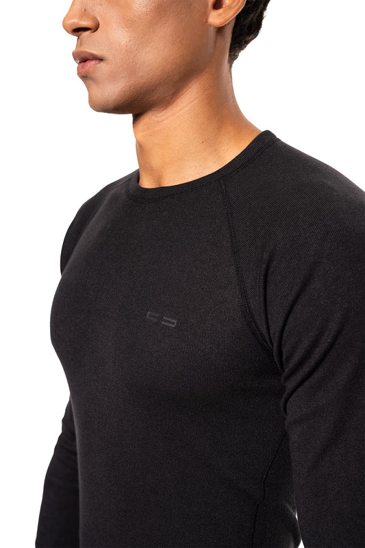 Männliches Modell trägt das Terra Base Layer Longsleeve Black mit subtiler Brustlogo, flachen Nähten und sportivem Schnitt für optimalen Komfort und Funktionalität.