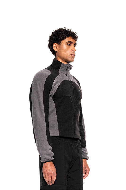 Junger Mann im Profil trägt die sportliche Light Fleece Jacket Black & Gray mit Reißverschluss und hohem Kragen, ideal für Layering und Komfort.