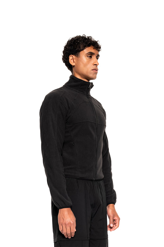 Mann trägt Light Fleece Jacket Black mit sportlicher Passform und zwei seitlichen Zip-Taschen. Perfekt als Midlayer dank geringem Gewicht und hoher Atmungsaktivität.