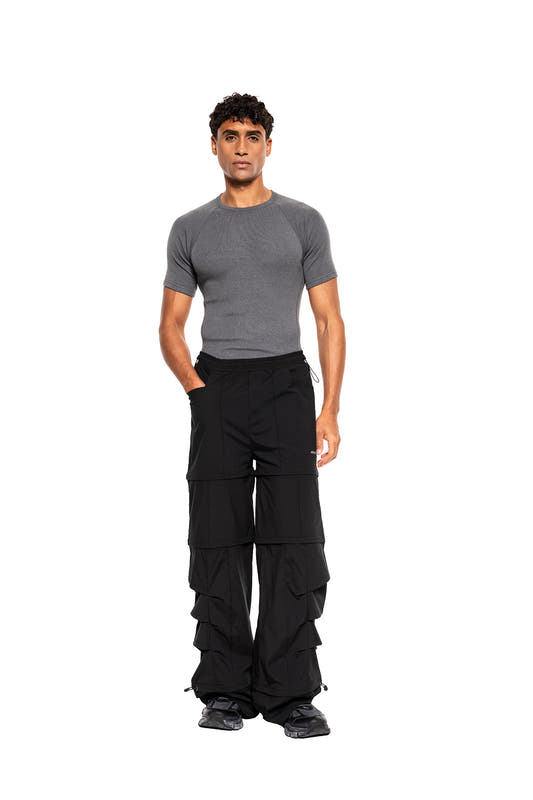 Model wears the Terra Base Layer T-Shirt Gray with loose, layered cargo pants and chunky sneakers, perfect for functional versatility and modern style.