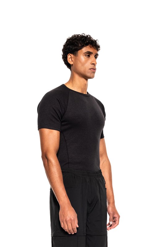 Junger Mann im Profil trägt ein schwarzes Terra Base Layer T-Shirt von OLAKALA, ideal als atmungsaktive, leichte Basisschicht für sportliche Aktivitäten.