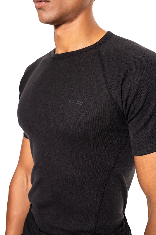 Person trägt ein eng anliegendes Terra Base Layer T-Shirt Black, das leicht und atmungsaktiv ist, ideal als erste Schicht für kalte Jahreszeiten.