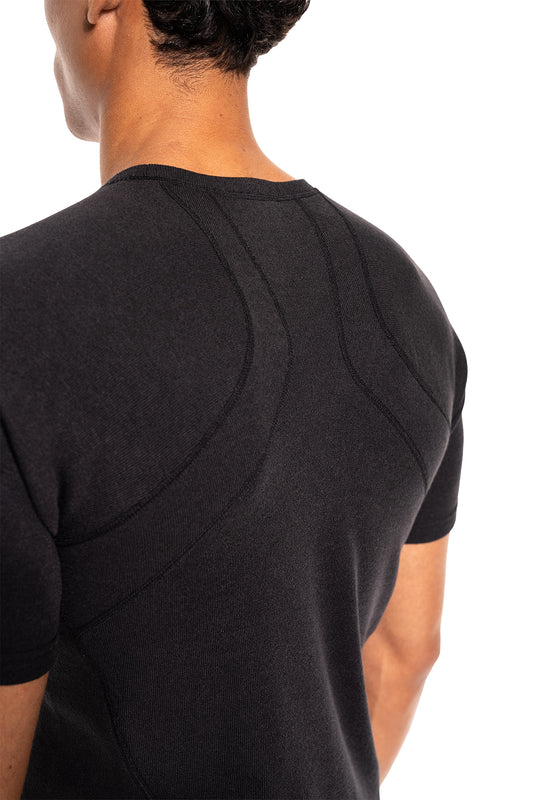Person trägt das Terra Base Layer T-Shirt Black mit konturierten Nähten am Rücken, ideal für vielseitige Anwendungen dank leichtem, atmungsaktivem Material.