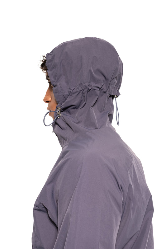 Person in profile with the Windbreaker Icon Gray, hood pulled tight, ideal for sports and everyday wear, offers freedom of movement and protection from the wind.