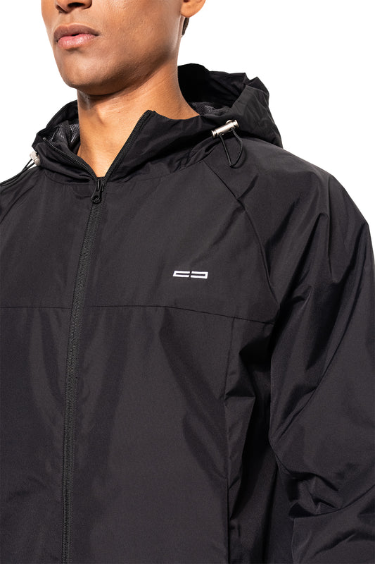 Person trägt den Windbreaker Icon Black mit Kapuze und Logo, sportlicher Schnitt, verstellbare Kordelzüge für Windschutz. Ideal für Training und Alltag.