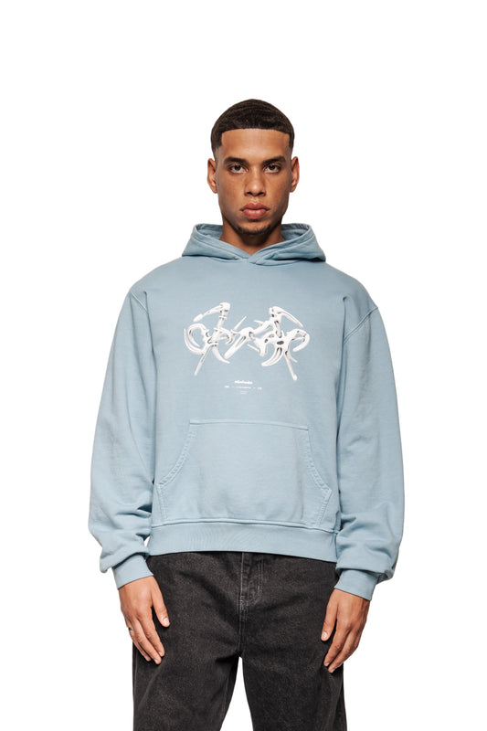 Junger Mann trägt Fusion Hoodie Blue mit Kängurutasche, abstrakter Grafik und Ripp-Bündchen, präsentiert in regulärer Passform. Ideal für den OLAKALA-Stil.