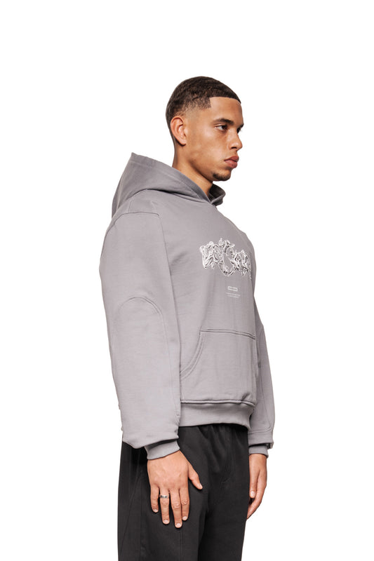 Männliches Modell trägt Greyzone Hoodie Dark Gray mit Kängurutasche und Siebdruck-Grafik. Sichtbare Ripp-Bündchen und Teilungsnähte, unisex.