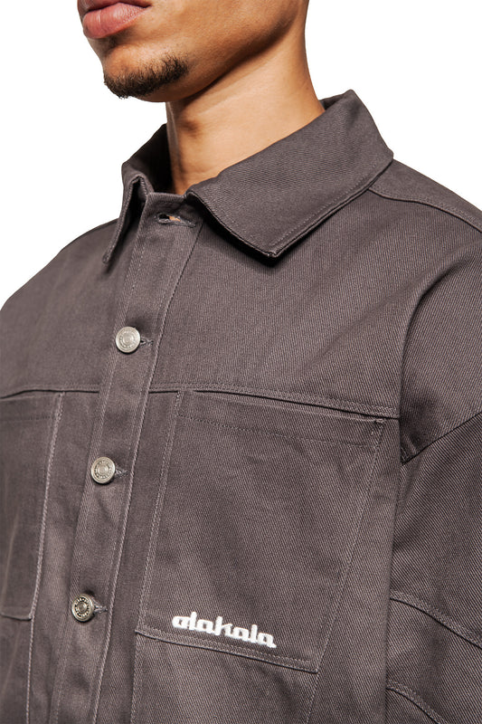 Close-up of a fashionable dark gray heavy anatomy cotton overshirt with press studs and 