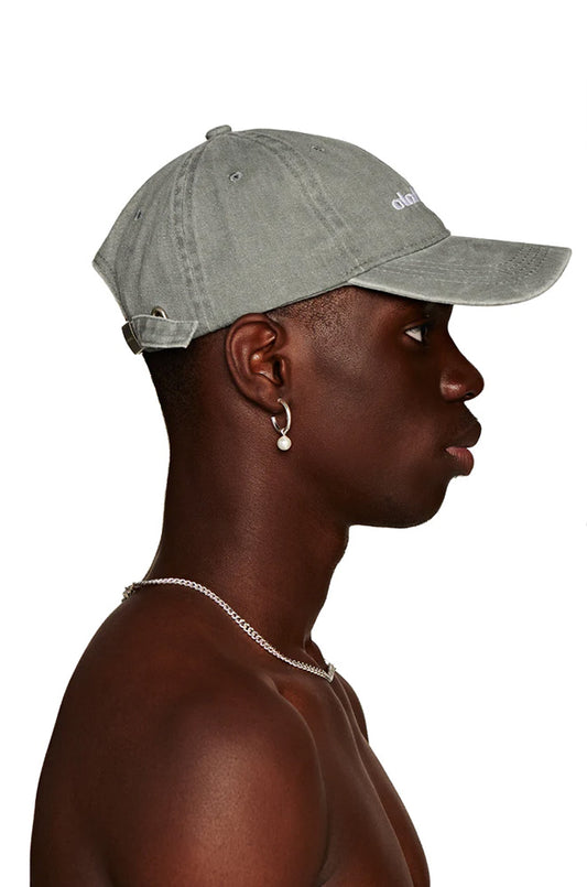 Man with Rhodes cap gray, adjustable with metal clip and embroidered OLAKALA logo on the front, presented.
