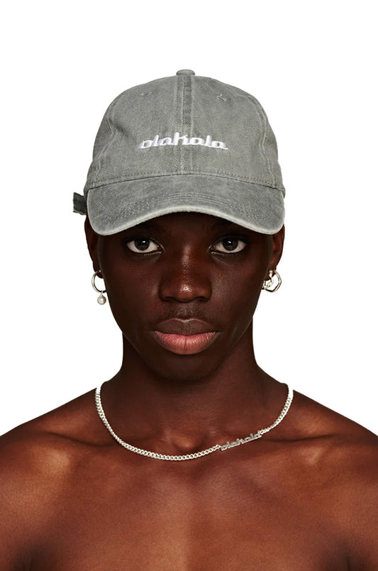 Man with Rhodes cap gray, adjustable with metal clip, embroidered OLAKALA logo on the front, fashionable accessory from the official OLAKALA® online store.