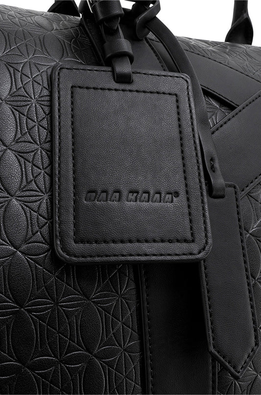 Nahaufnahme eines schwarzen Lederanhängers des CC Debossed Weekender Bag Black mit OLAKALA Monogramm für luxuriöse Reisen.