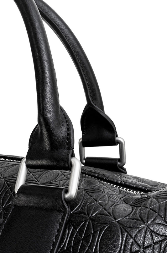 Nahaufnahme der CC Debossed Weekender Bag Black mit OLAKALA Monogramm, abnehmbarem Schulterriemen und Metallreißverschluss, ideal für stilvolle Reisen.