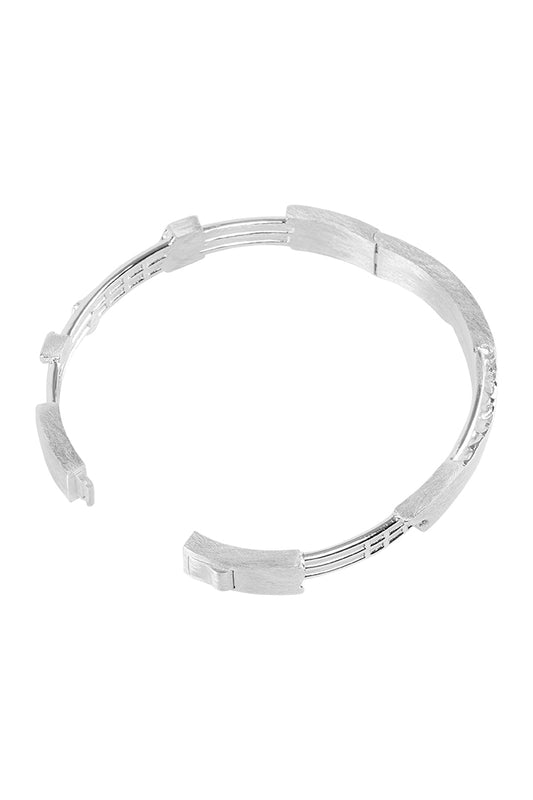 Brushed Cuff Bracelet: Versilberter Armreif im „zerstörtem“ Look, eingraviertes OLA KALA Logo, mit einem Durchmesser von 62 mm und mehreren Silberbändern.