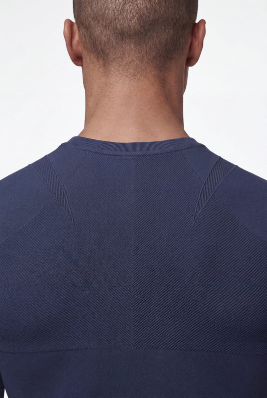 Person von hinten im Compression Tanktop Navy Blue, mit nahtloser Strickstruktur und geometrischen Mustern, die eine präzise Passform und Bewegungsfreiheit fördern.