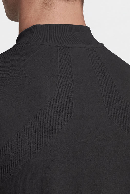 Nahaufnahme des OLAKALA Compression Halfzip Black, zeigt den gerippten Kragen und die nahtlose, strukturierte Strickmusterung für optimale Passform und Bewegungsfreiheit.