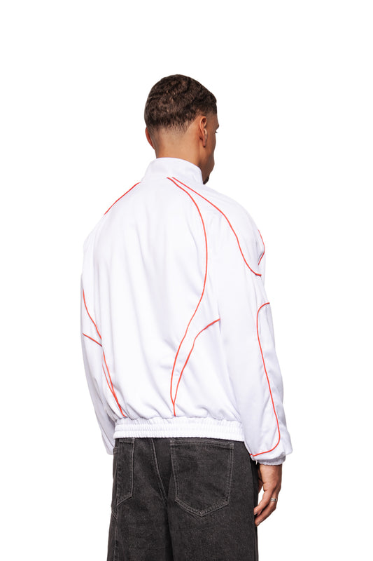 Male model in Rave Trackjacket White Red with red piping, stand-up collar and elasticated hem, worn with washed-out black jeans, back view.