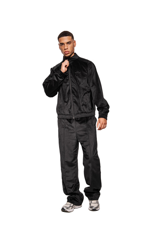 Men's style in Sports Velour Jacket Black made of high-quality velour with dividing seams, elasticated cuffs and a loose fit, combined with matching track pants and sneakers.