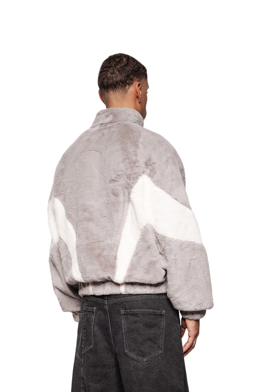 Male model wears the Two-Toned Fur Jacket Gray with stand-up collar and raglan sleeves, combined with black jeans.