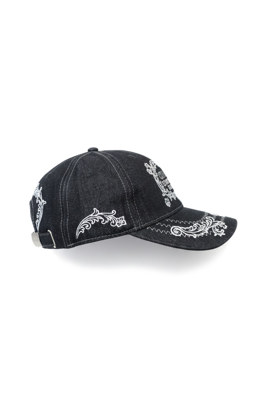 Mokka Cap mit schwarzem Denim, weißer Paisley-Stickerei auf Schirm und Panels, verstellbarem Metallverschluss und traditioneller 6-Panel-Konstruktion für universellen Komfort.